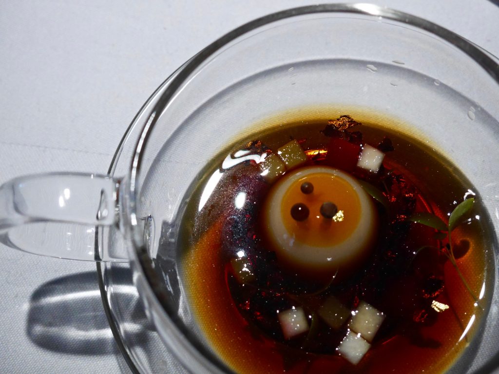teacup prepared with a turnip mousse, designed to resemble a mock turtle egg topped with delicate enoki mushrooms.