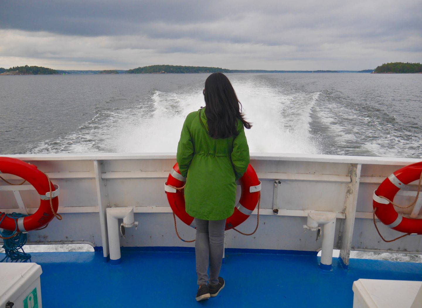 sima stood in a green jacket at the back of a cinderella boat overlooking the sea