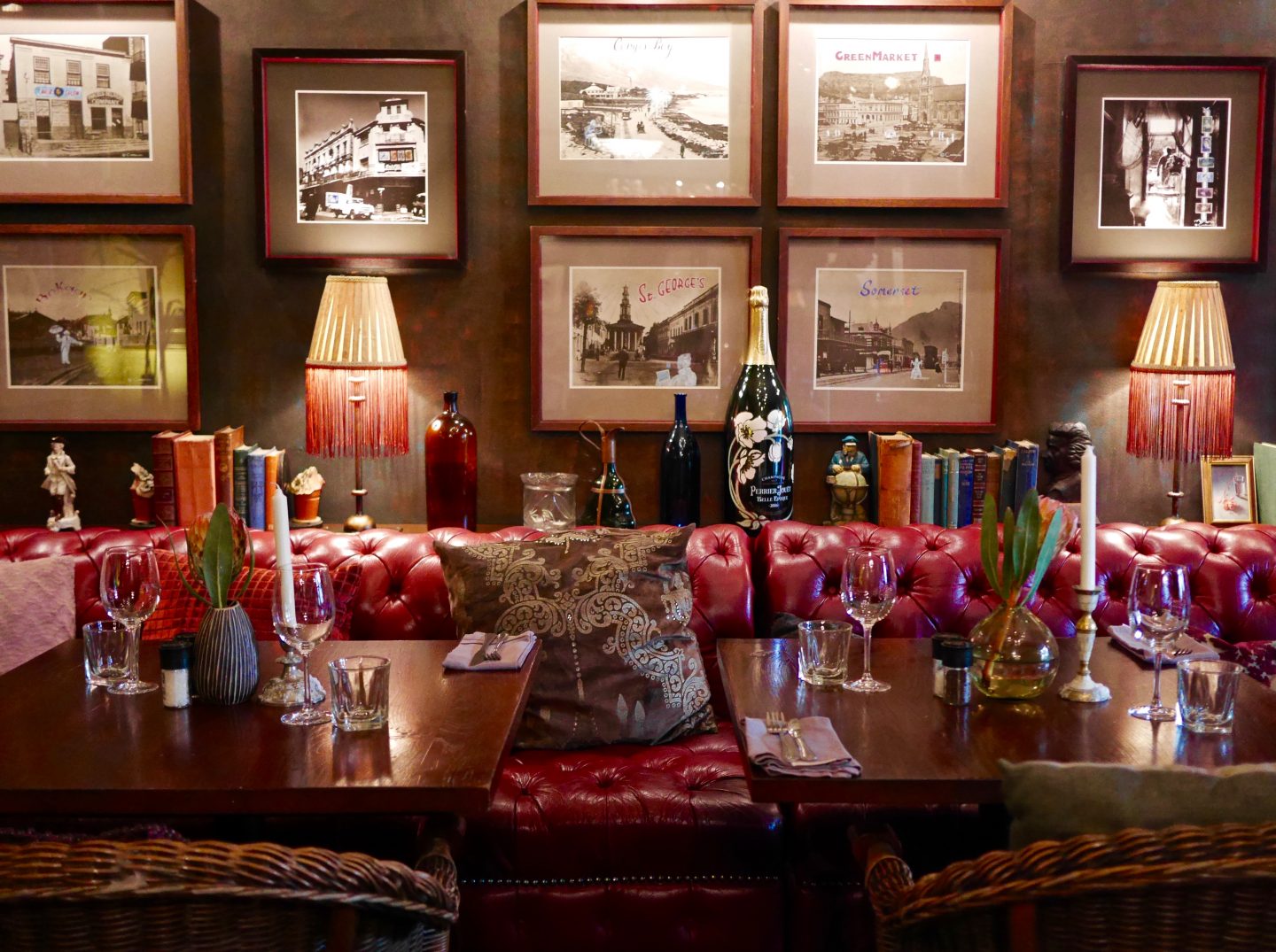 picture of two tables with red leather seats, wine glasses and wooden walls in Conde Nast