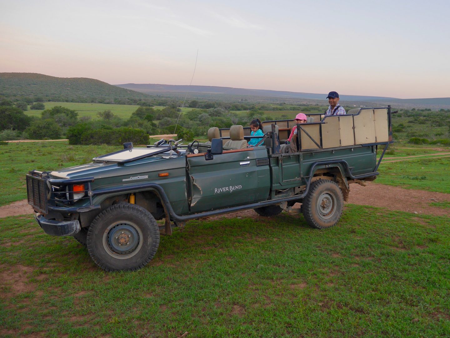 view of family on an open sided green safari jeep