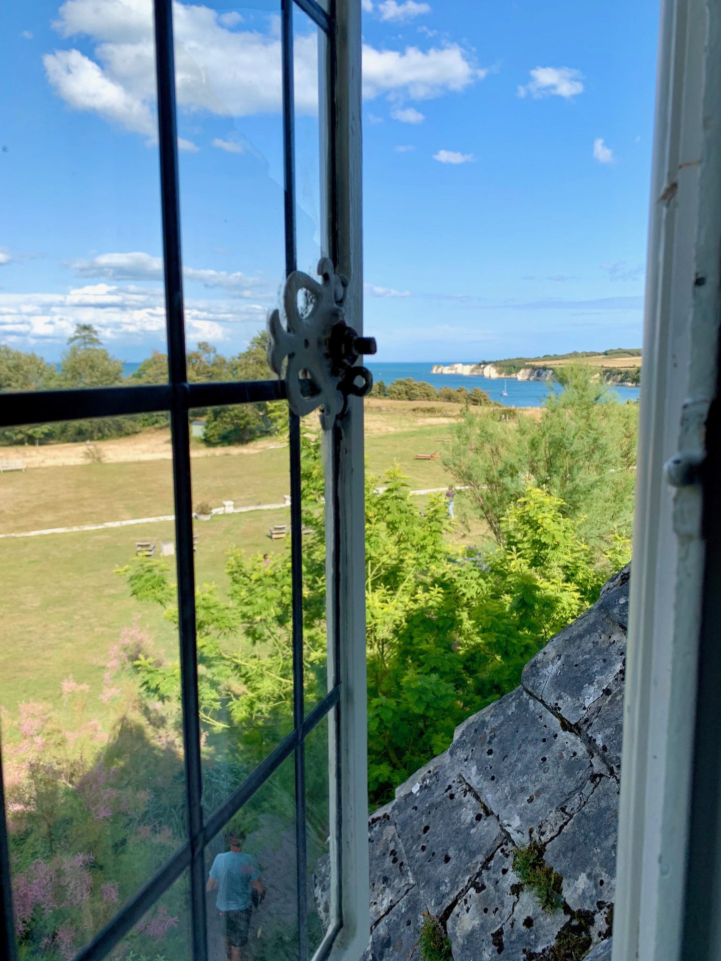 view out of the window towards the beach and sea across fields