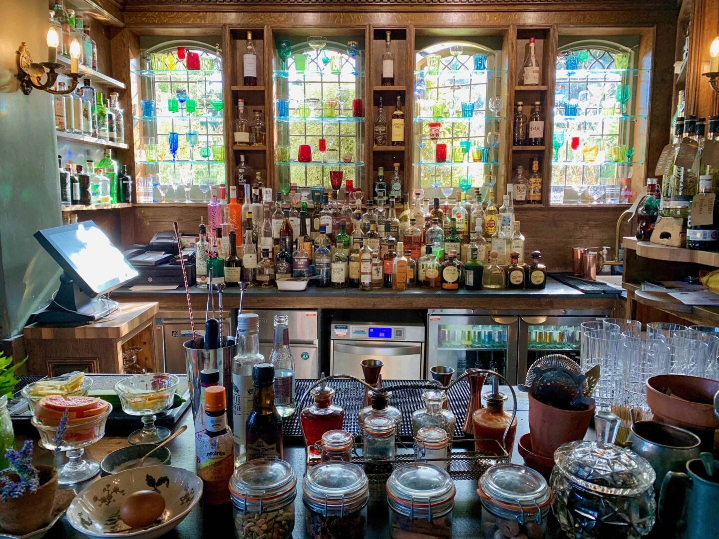 behind the wood panelled bar with sideboards full of drinks and snacks