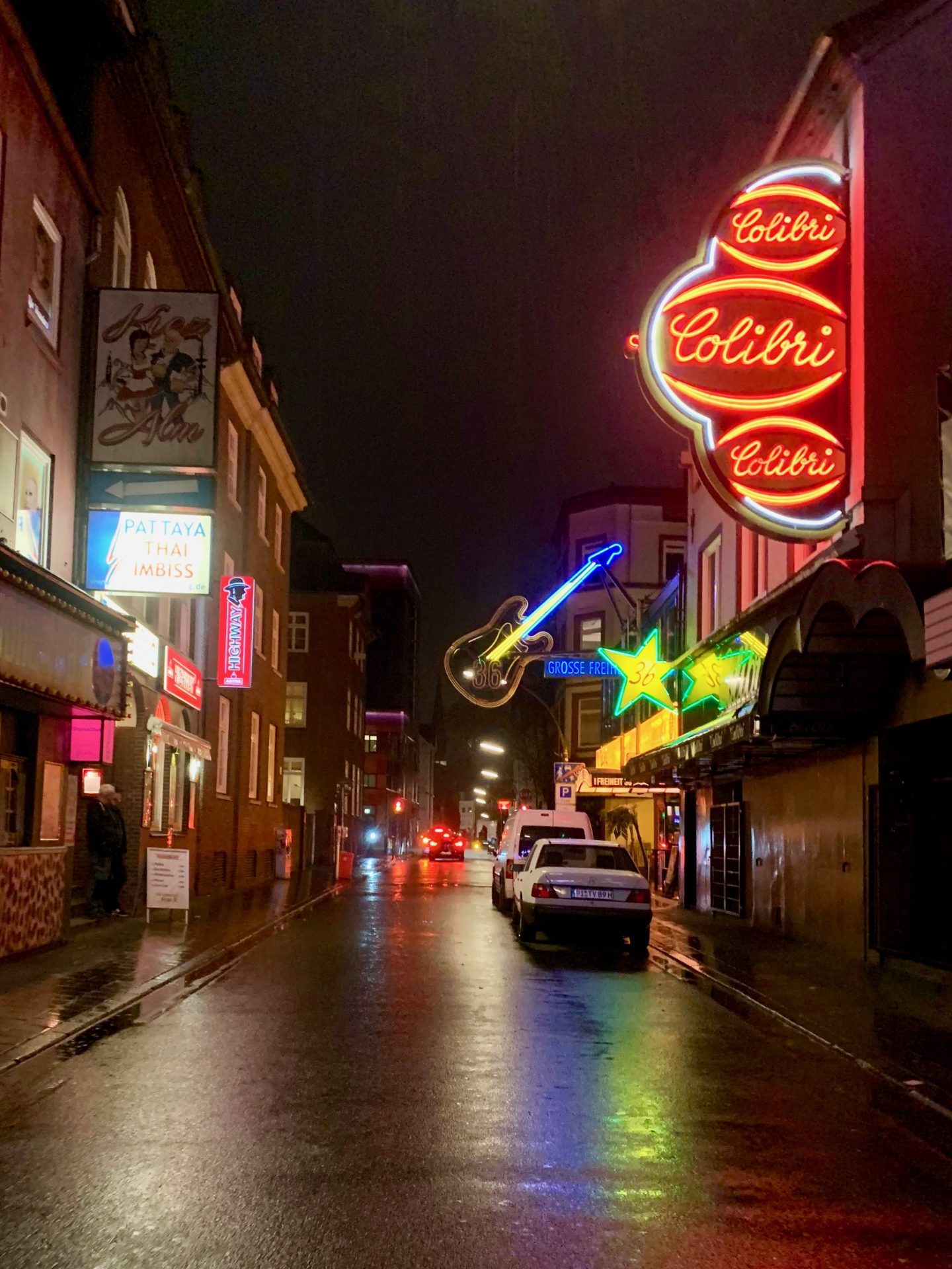 view looking down the Reeperbahn at nighttime surrounded by neon lights