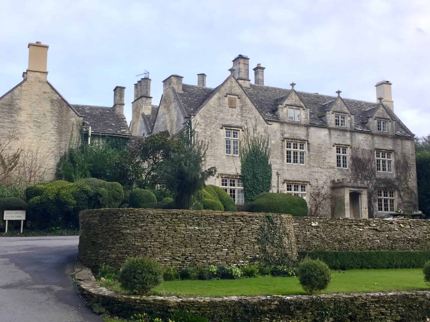 picture of Barnsley house surrounded by grassed gardens, tall brick built walls and shubbery in The Cotswolds