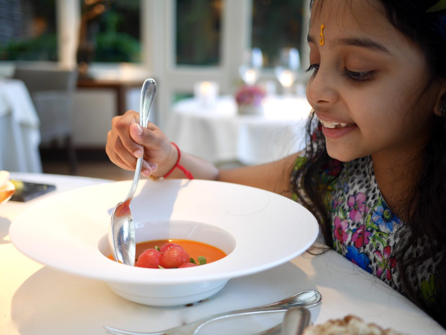 simas daughter eating roasted tomato soup in a white bowl