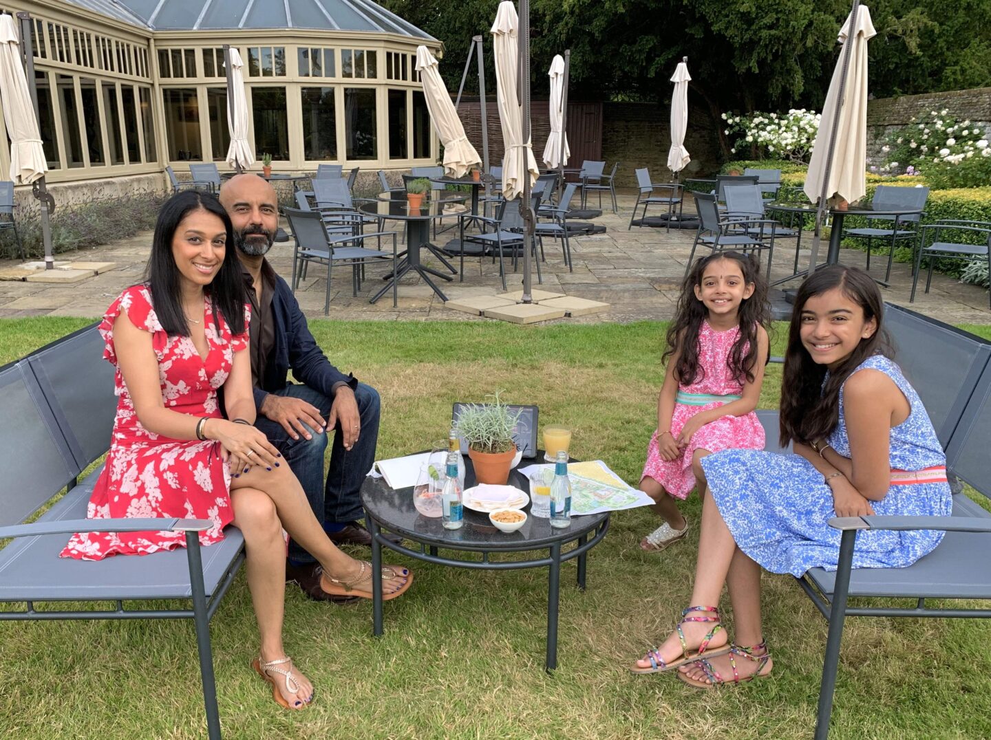 view of sima and family sat on metal benches in the gardens